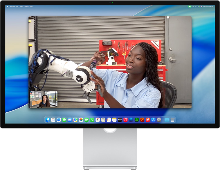 Dos personas en una videollamada en el Studio Display, Encuadre Centrado las mantiene en el centro de la imagen incluso cuando una de ellas se mueve para reparar un equipo