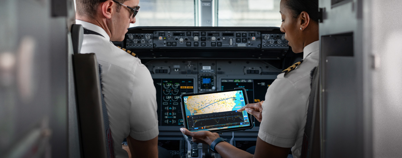 En una cabina, dos pilotos ven un mapa en la pantalla de un iPad.