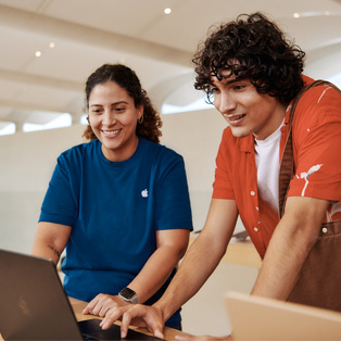 Apple Store-medewerker die met een klant bezig is op een MacBook.