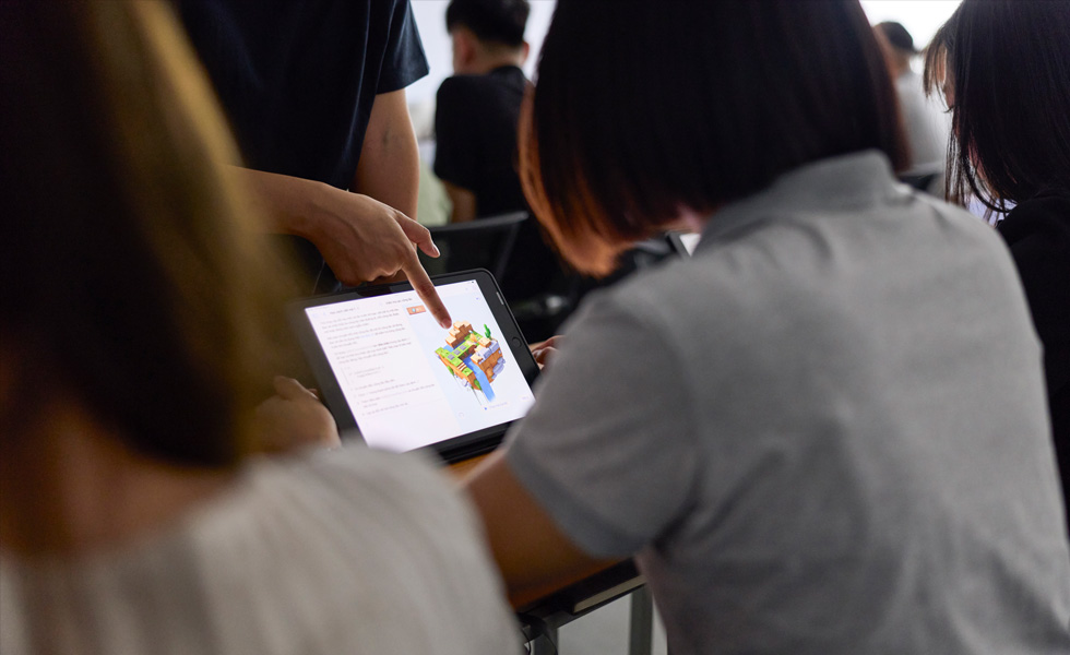 Eine Person gibt Feedback zu einem Objekt auf einem Tablet Display in einem Klassenzimmer